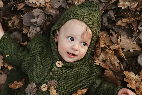 Young boy lying in the leaves